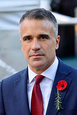 Portrait of Malinauskas wearing a dark suit, white shirt and red tie
