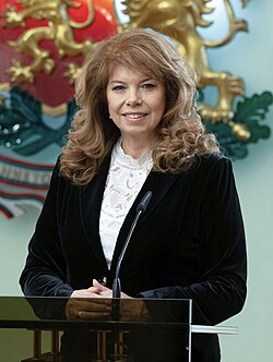Official presidential portrait of Iotova smiling and wearing a white shirt and a blue suit jacket.