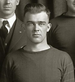 Black and white photo of college student dressed in a football uniform