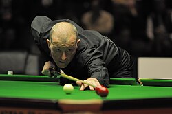 Davis, bent over the table, lining up a shot