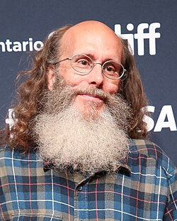 Photo of a middle-aged man wearing glasses with long hair and large beard.