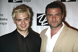 Two smiling men attending an awards ceremony.